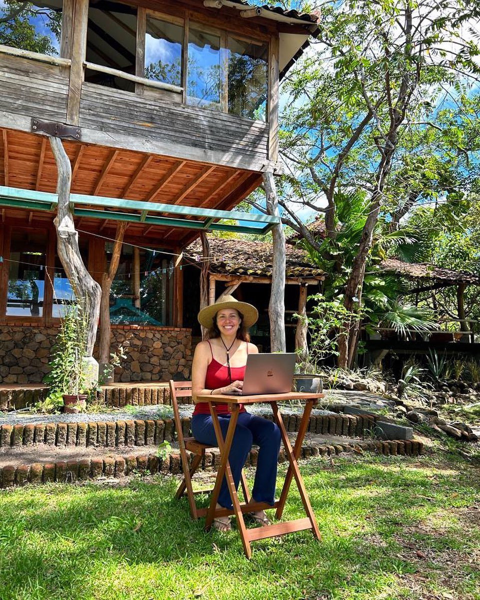 Woman working at a laptop outside the welcome center at Veritas Village Panama