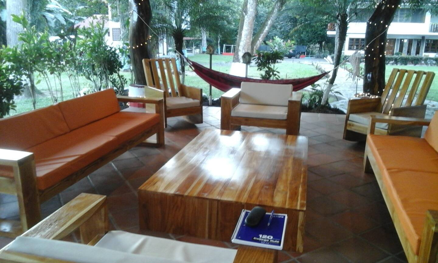 Covered outdoor lounge with sofas, a hammock and a wood table
