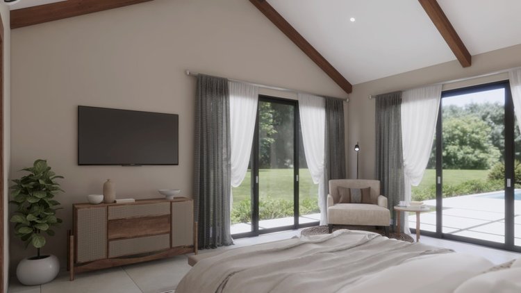 Modern bedroom with large glass sliding doors, beige walls, wooden ceiling beams, a flat-screen TV on the wall, a wooden sideboard, a potted plant, a beige armchair with a pillow, a small side table, and a view of greenery outside.